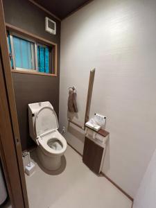 ein kleines Badezimmer mit Toilette und Fenster in der Unterkunft moksa House ヒリゾ浜まで車で10分 in Kanō + 16 Fotos