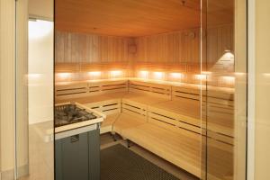 a sauna with wooden cabinets and a stove at Dorint An der Messe Köln in Cologne