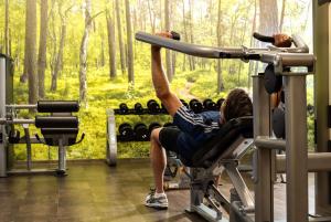eine Frau trainiert an einem Gerät in einem Fitnessstudio in der Unterkunft Dorint An der Messe Köln in Köln