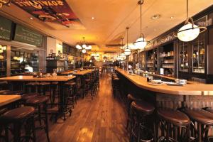 eine Bar mit Holztischen und -stühlen in einem Restaurant in der Unterkunft Dorint An der Messe Köln in Köln