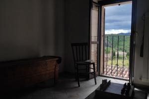 um quarto com uma cadeira e uma janela com vista em Il Racconto Aria em Nocera Umbra