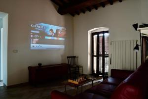 een woonkamer met een bank en een groot scherm bij Il Racconto Aria in Nocera Umbra