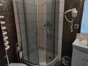 W łazience znajduje się prysznic ze szklanymi drzwiami. w obiekcie Zacisze Mazury w mieście Kętrzyn