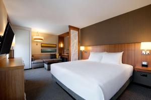 Habitación de hotel con cama grande y sala de estar. en Hyatt Place Houston/The Woodlands en The Woodlands