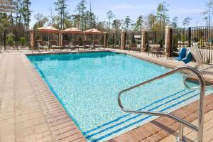 a swimming pool at a hotel with tables and chairs at Hyatt Place Houston/The Woodlands in The Woodlands