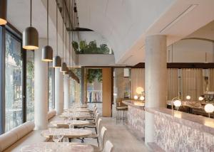 uma fila de mesas num restaurante com janelas grandes em The Calile Hotel em Brisbane