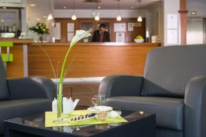 stół z białym kwiatem w wazie w obiekcie Essential by Dorint Köln-Junkersdorf w Kolonii