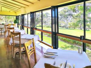 a restaurant with tables and chairs and large windows at Breakfree Wirrina Cove in Wirrina Cove