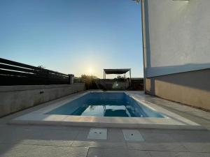 uma piscina ao lado de um edifício em La Prima Privlaka Luxury Apartments I em Privlaka