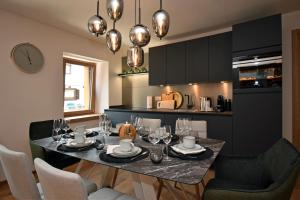 a dining room with a table and chairs and a kitchen at Design Residence Nellere in Padola