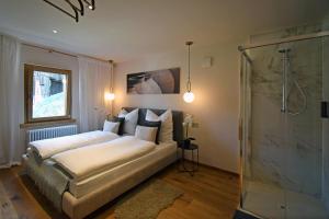 a bedroom with a king sized bed and a shower at Design Residence Nellere in Padola