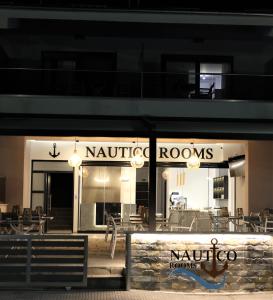 restauracja ze stołami i krzesłami przed nią w obiekcie Nautico Rooms w mieście Keramotí