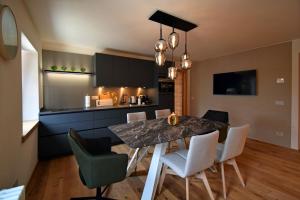 uma cozinha e sala de jantar com mesa e cadeiras em Design Residence Nellere em Padola