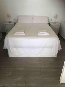 a white bed with two towels on top of it at PRIMERA LÍNEA DE PLAYA, LA ARENA A TUS PIES in Aguadulce