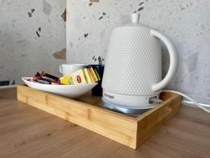 a white blender on a wooden tray with a bowl of food at Apartament w Śródmieściu in Gdynia