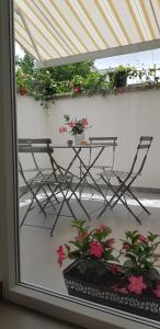una mesa y sillas en un balcón con flores en Il Cortile Segreto, en Lecce