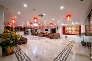 HOTEL ANAND INTERNATIONAL في بود جايا: غرفة معيشة كبيرة مع كنب وكراسي واضاءات
