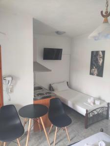 a small room with a bed and two chairs and a table at Vigla House in Sykia Chalkidikis