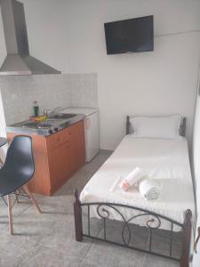 a bedroom with a bed and a kitchen with a sink at Vigla House in Sykia Chalkidikis