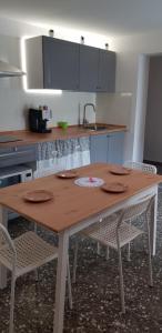 cocina con mesa de madera y 2 sillas en Il Cortile Segreto, en Lecce