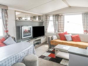 un soggiorno con divano e TV di Goodison Devon Cliff a Exmouth