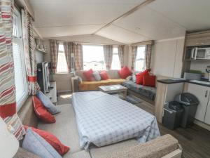 a living room with a couch and a table in a caravan at Goodison Devon Cliff in Exmouth