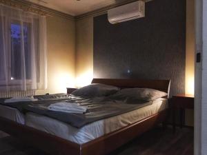 - une chambre avec un grand lit et une fenêtre dans l'établissement Arany Vendégház Zamárdi, à Zamárdi