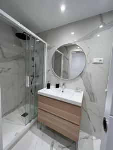 uma casa de banho com um lavatório, um chuveiro e um espelho. em Chapitela Suite em Pamplona