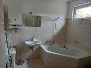 La salle de bains est pourvue d'une baignoire et d'un lavabo. dans l'établissement Arany Vendégház Zamárdi, à Zamárdi