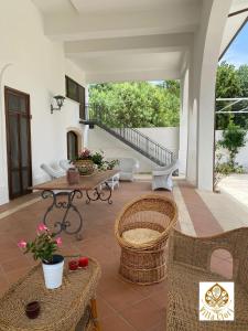 een patio met een tafel en stoelen en een trap bij Villa Clori in Salice Salentino