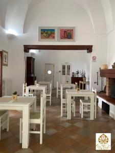 un comedor con mesas blancas y sillas blancas en Villa Clori, en Salice Salentino