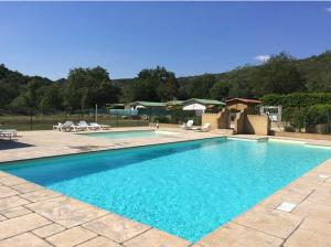 a large blue swimming pool with chairs and tables at Chalet des Lucioles in Montréal