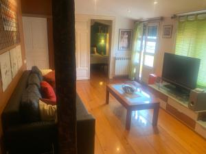 a living room with a couch and a table and a television at Ático en el centro de Logroño in Logroño