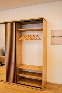 ein Schrank mit Holzregalen und einer Wand in der Unterkunft Meridiano apartamentai in Klaipėda