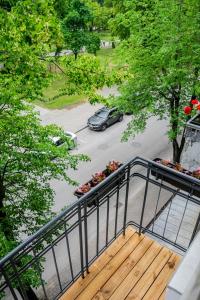 einen Balkon mit Holzterrasse und ein Auto auf einem Parkplatz in der Unterkunft Meridiano apartamentai in Klaipėda