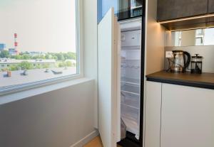 a kitchen with an open refrigerator with a window at Beautiful apartment next to the Kalev Stadium in Tallinn