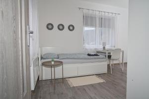 Schlafzimmer mit einem Bett, einem Tisch und einem Fenster in der Unterkunft Apartmány Daros in Dvůr Králové nad Labem