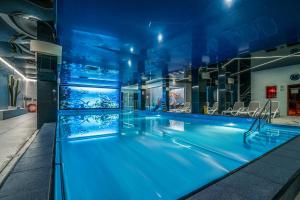 una piscina con iluminación azul en un edificio en Hotel SPA Faltom Gdynia Rumia, en Rumia