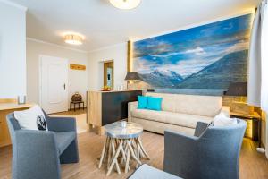 a living room with a couch and two chairs at Berghotel Ronach in Königsleiten