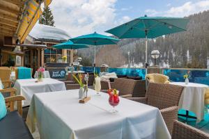 a couple of tables with umbrellas on a patio at Mountainclub Hotel Ronach in Königsleiten