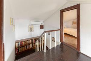 a room with a staircase with a bed and a mirror at Šentjane bay view house in Portorož