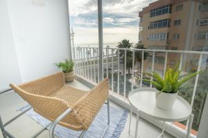 balkon ze stołem i krzesłami oraz oknem w obiekcie Enjoy Malaga on the beachfront w Maladze