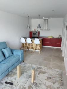 een woonkamer met een blauwe bank en een keuken bij Villa Cariño - Apartamento en Malpica de Bergantiños in Malpica