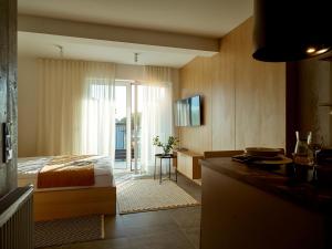 een slaapkamer met een bed en een bureau met een televisie bij Lake-Apart Apartamenty Mielno in Mielno