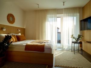 een slaapkamer met een bed en een groot raam bij Lake-Apart Apartamenty Mielno in Mielno