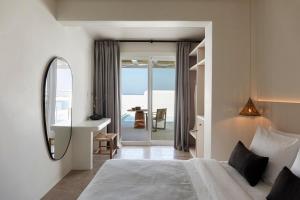 a bedroom with a bed and a sink and a mirror at Porto Mykonos in Mikonos +113 photos