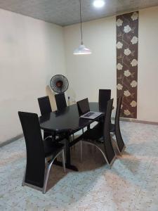 a black dining room table and chairs in a room at Charming 2-Bed Cottage in Benin City in Benin City