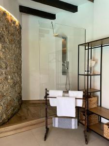 a bathroom with a glass shower and two white chairs at Villa Bournella in Ipsos
