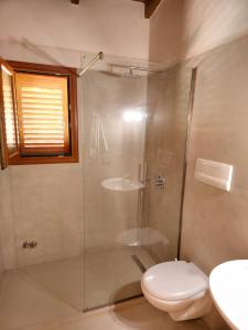 uma casa de banho com um chuveiro, um WC e um lavatório. em Resort Te Zagolli em Orikum