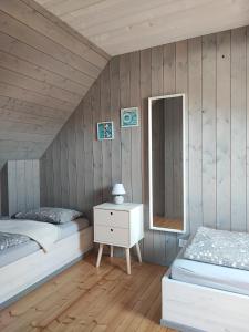 1 Schlafzimmer mit 2 Betten, einer Kommode und einem Spiegel in der Unterkunft Słoneczny Raj Apartamenty Domki apartamentowe in Sarbinowo